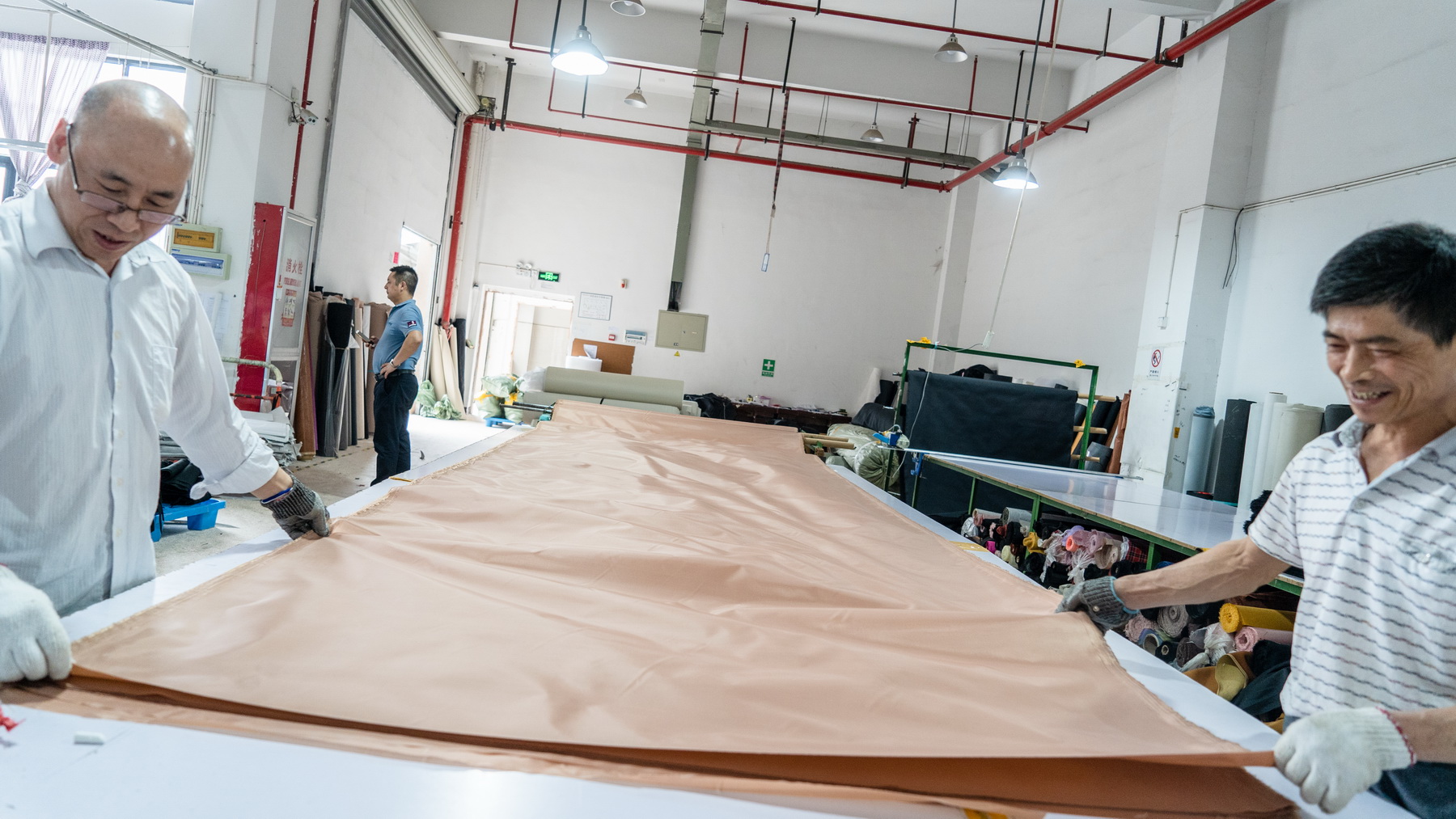 Workers cutting and preparing fabric for bags