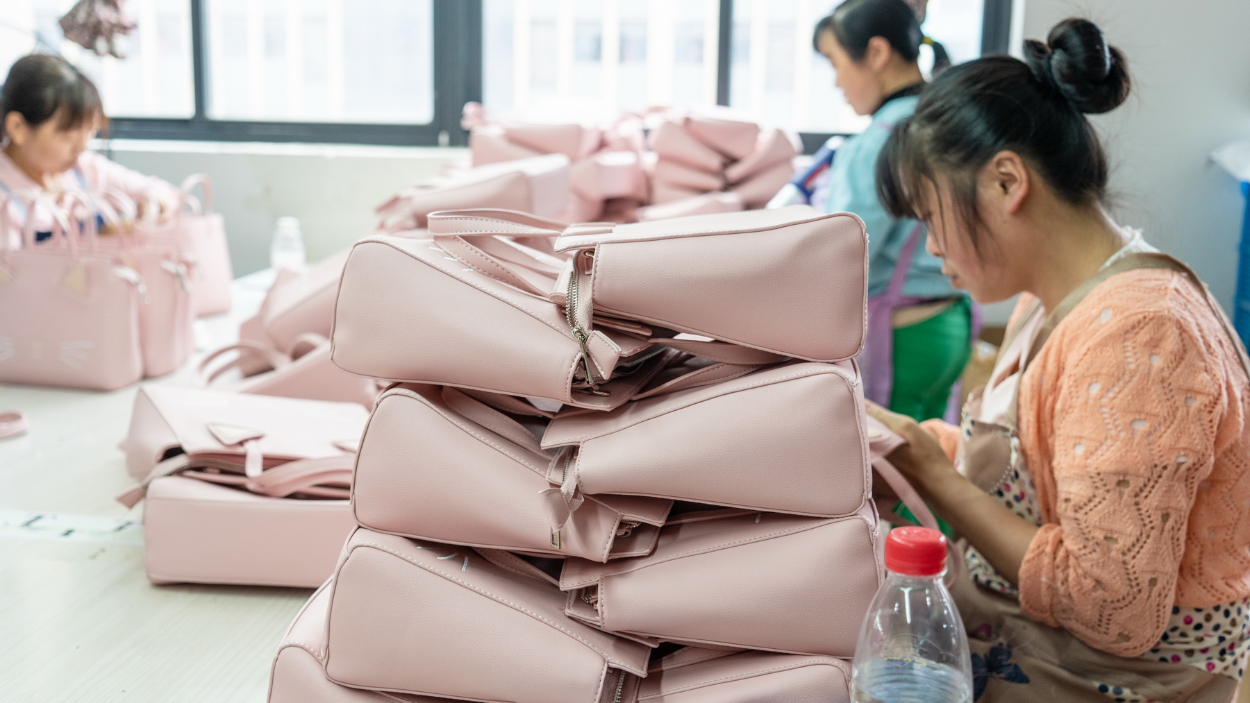 Workers sorting and stacking finished pink bags
