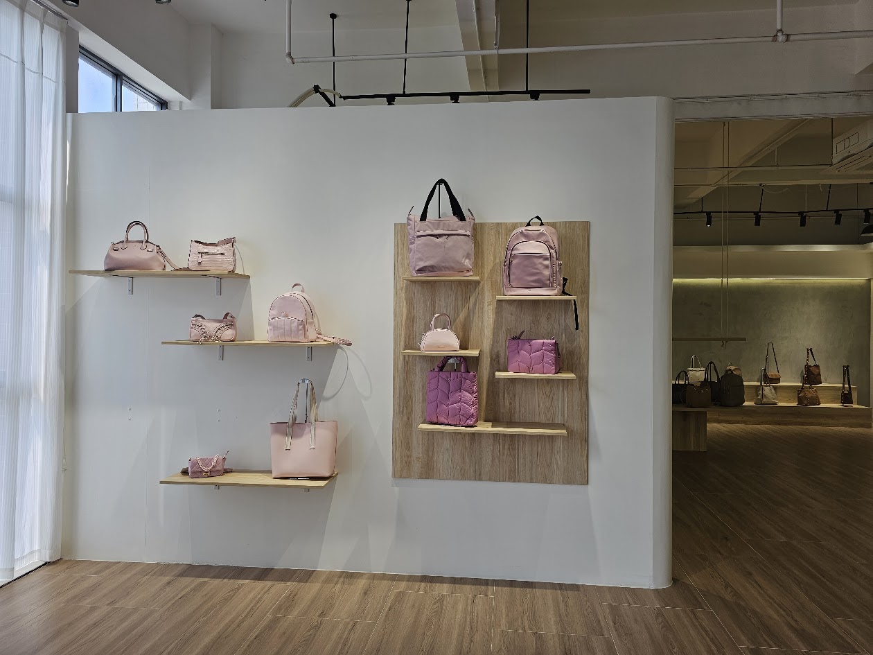 Pink bags displayed on a showroom wall