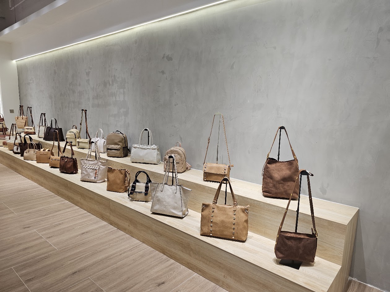 Handbags arranged along a showroom display